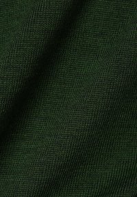 Tessuto verde testurizzato con una vista ravvicinata, caratterizzato da un motivo a maglia stretta e sottili variazioni di tonalità sulla superficie.