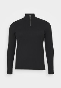 Sort ribbet langærmet pullover med høj krave og sølv lynlås lukning ved halsen. Den har et tætsiddende design og struktureret materiale.