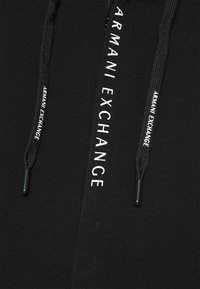 Felpa nera con zip, caratterizzata dal logo 'ARMANI EXCHANGE' stampato in bianco nell'area della zip e dei lacci con dettagli neri in rilievo.
