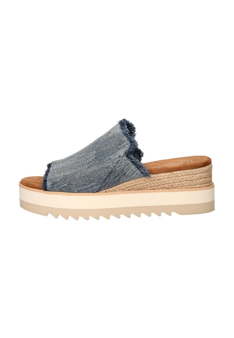 Blauwe denim slip-on sandaal met franjes, een gevoerd voetbed en een dikke, getextureerde wigzool met een zigzagpatroon.