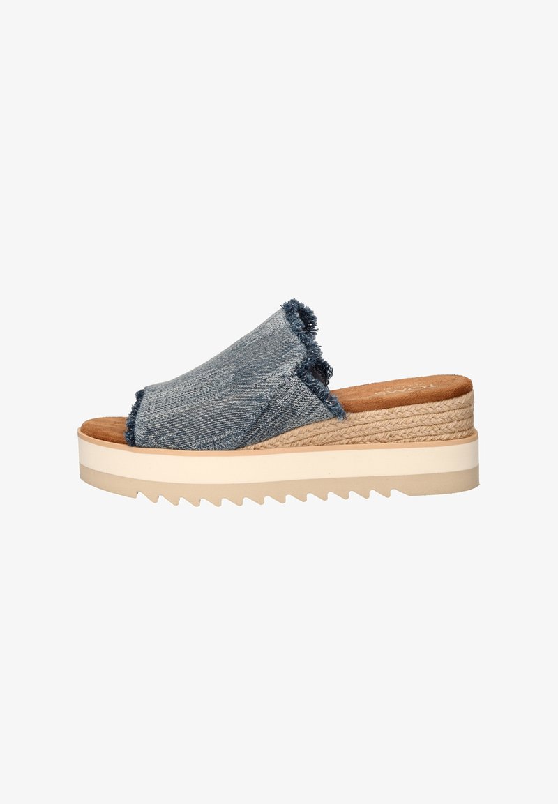 Blauwe denim slip-on sandaal met franjes, een gevoerd voetbed en een dikke, getextureerde wigzool met een zigzagpatroon.