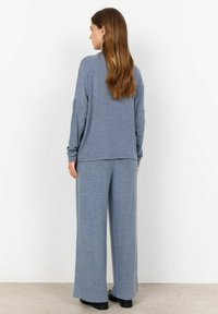 Light blue, soft fabric loungewear set featuring a loose long-sleeve top and wide-leg pants, both with a smooth texture and relaxed fit.