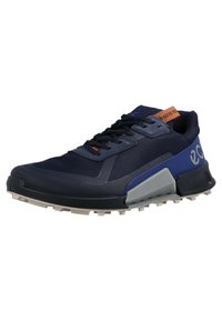 Navy blue athletic shoe with black laces, gray and blue accents, rugged white sole, and orange pull tab labeled "GORE-TEX."
