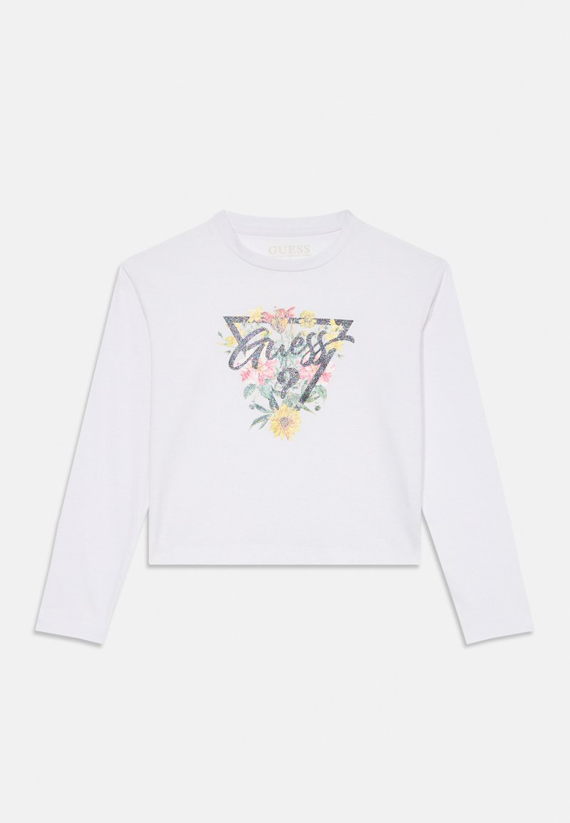 Balts ilgas piedurknes kropp tops ar grafisko dizainu, kurā ir krāsaini ziedu raksti un vārds "Guess" spīdīgā melnā fontā.