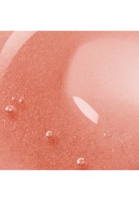 Glossy pink liquid with fine shimmer particles and a few small air bubbles on the surface.