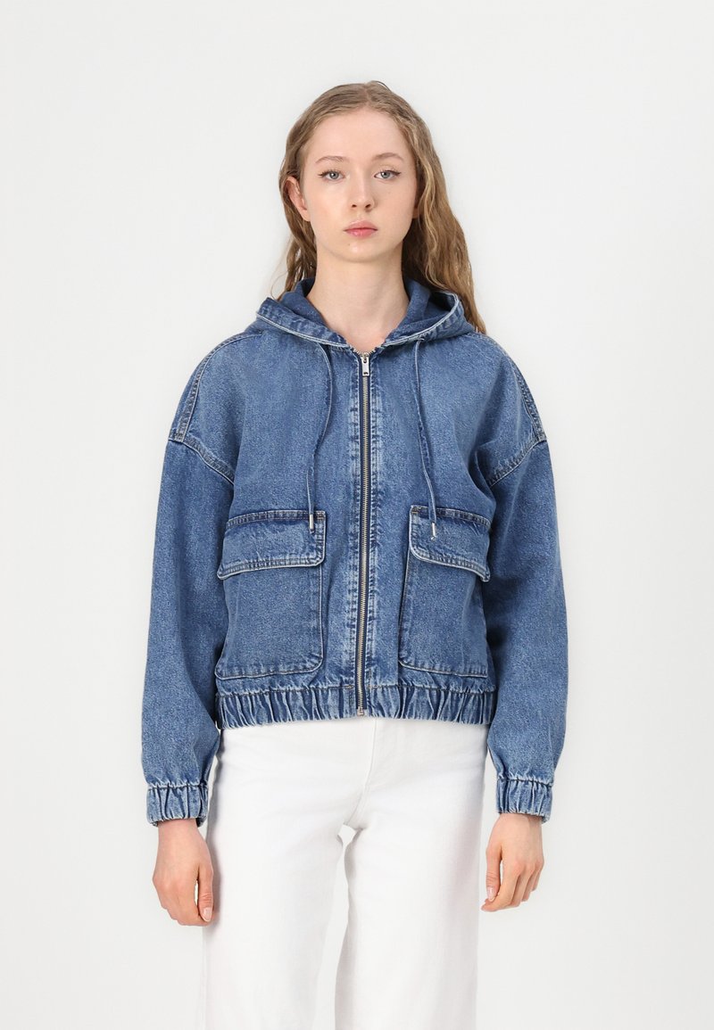 Jeans jakna s kapuljačom, s patentnim zatvaračem sprijeda, dva velika džepa, elastični završetak i manšete, u srednjoj plavoj boji.