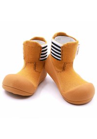 Zapatillas tipo calcetín de color naranja con suela de goma, que presentan un acento acanalado en negro y blanco en el tobillo y una parte superior texturizada.