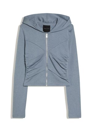 Lichtblauwe cropped hoodie met lange mouwen, ritssluiting aan de voorkant, capuchon en geplooide stofdetails op de borst.