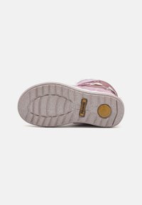 Rosa barnesneaker med strukturerte gummisåler, dekorativ stikning og flere snøre-løkker. Logoen er synlig på siden.