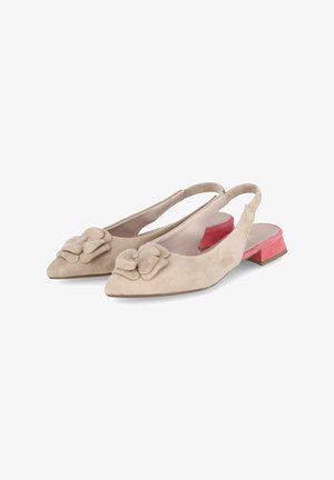 Beige suede slingback shoes with a pointed toe, featuring a flower accent and a short, rectangular red heel. Smooth texture overall.