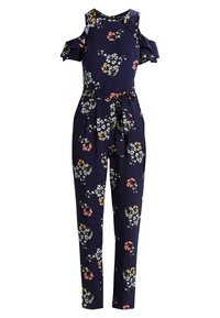 Kwiatowy kombinezon w granatowym kolorze, z odkrytymi ramionami, falbanami i paskiem do związania. Materiał wydaje się lekki i zwiewny z żywym wzorem.