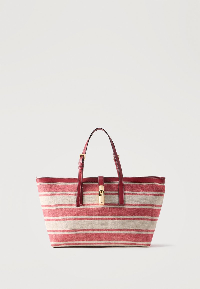 Τσάντα χειρός με κόκκινες και μπεζ ρίγες, κόκκινες δερμάτινες λαβές και χρυσό κούμπωμα, όρθια σε απλό φόντο.