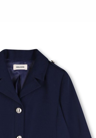 Veste bleu marine avec col, boutons argentés et épaulette, affichant l'étiquette de la marque "Zadig & Voltaire" à l'intérieur du col.