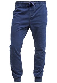 Pantalon de jogging slim bleu marine avec taille élastique et cordon de serrage, poignets côtelés et poches latérales.