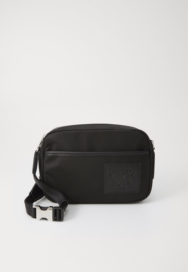 Črn najlon crossbody nahrbtnik z strukturiranim logotipom, zadrgo in nastavljivim trakom z srebrnim zaponko.