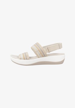 Beige sandal with two striped fabric straps and a back strap, resting on a white platform sole with a rounded toe and textured finish.
