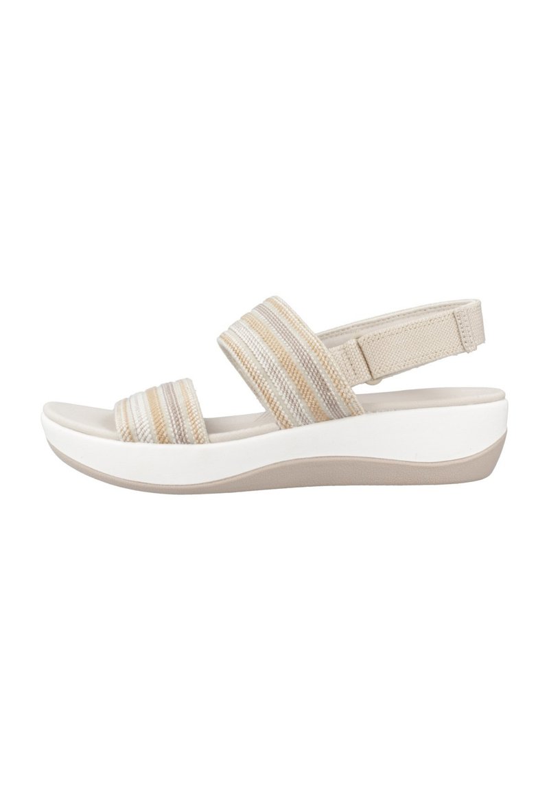 Sandalia beige con dos tiras de tela a rayas y una tira trasera, reposando sobre una suela de plataforma blanca con punta redondeada y acabado texturizado.