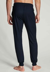 Marineblauwe joggers met een elastische tailleband en smalle boorden, gemaakt van een zachte stof, met een eenvoudig ontwerp zonder extra patronen.