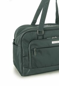 Borsa da viaggio in tessuto verde scuro con manici doppi, scomparti con zip e una finitura leggermente texturizzata. Presenta dettagli hardware con marchio.