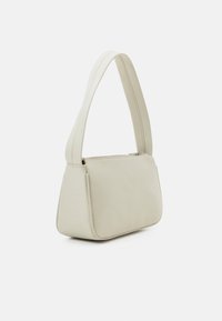 Borsa a spalla beige con una texture liscia, forma rettangolare e una singola tracolla ampia, dotata di chiusura con zip e dettagli di cucitura discreti.