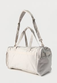Φωτεινή γκρι ορθογώνια τσάντα duffel με δύο κοντές χειρολαβές και έναν ρυθμιζόμενο επενδυμένο ιμάντα ώμου σε απλό λευκό φόντο.