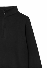 Pullover negro con cremallera en el cuello, hecho de una tela suave, que presenta un alto cuello y detalles de costura sutiles en la zona de la cremallera.
