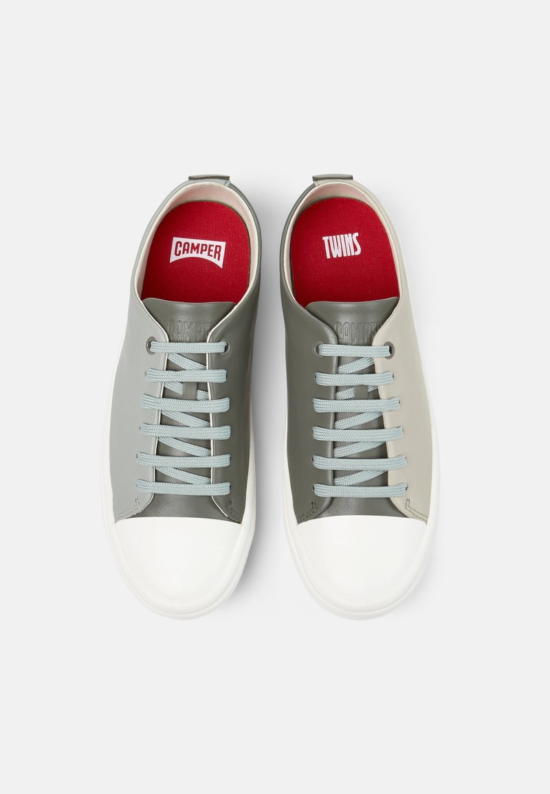 Graue Sneakers mit hellblauen Schnürsenkeln, weißen Gummisohlen und roten Innensohlen, die das Branding "CAMPER" und "TWINS" zeigen. Draufsicht.