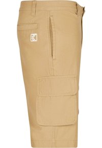 Bežové cargo šortky vyrobené z ľahkej tkaniny, s dvoma bočnými vreckami a pravým vreckom na stehne so zapínaním na suchý zips. Malé logo na opasku.