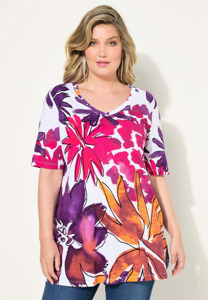 Witte bloemen tuniek blouse met levendige roze, paarse en oranje patronen. Heeft korte mouwen en een V-hals ontwerp, gemaakt van zachte stof.