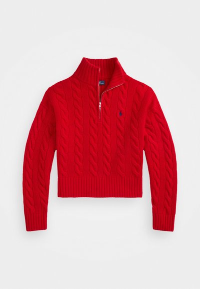 Red cable-knit sweater with a high collar, half zip, and ribbed cuffs. Features a small embroidered logo on the chest.