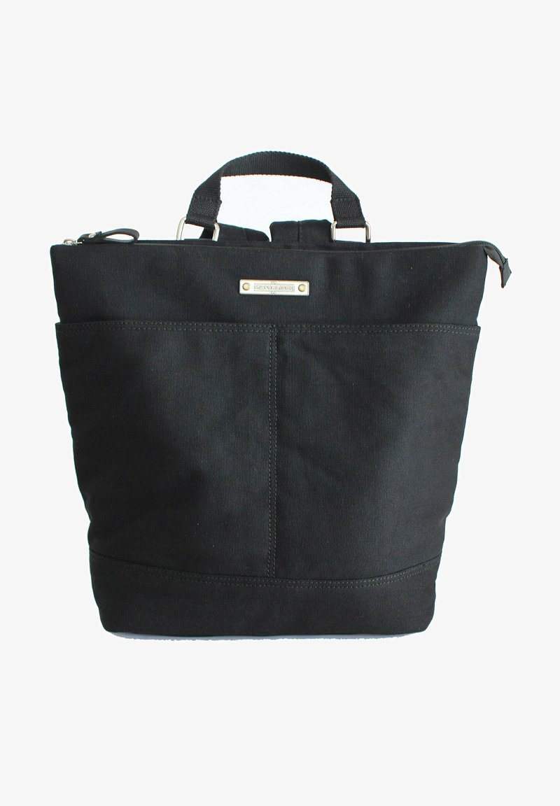 Schwarze Canvas-Tasche in quadratischer Form, mit einem oberen Reißverschlussverschluss, doppelten Tragegriffen und einer Fronttasche mit minimalem Zubehör.