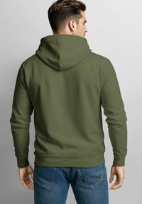 Olive green hooded sweatshirt with long sleeves, relaxed fit, and smooth texture. Paired with denim jeans featuring rear pocket accents.