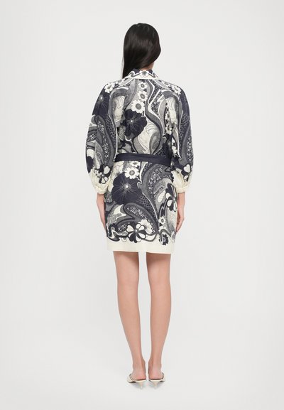 Rochie cu un model marin și crem, cu designs florale și paisley, având talie ajustată și mâneci bufante, realizată dintr-un material ușor.