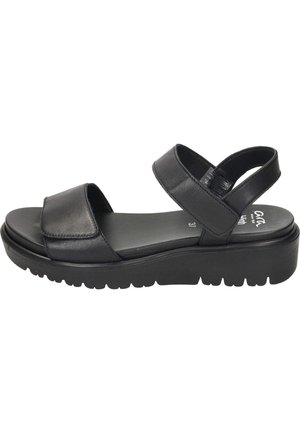 Černá platformová sandála se dvěma nastavitelnými pásky, polstrovanou stélkou a texturovanou podrážkou pro lepší přilnavost.