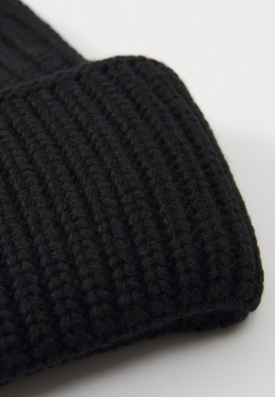 Berretto lavorato a maglia nero con una texture a coste, filato spesso e orlo ripiegato, progettato per calore e comfort.