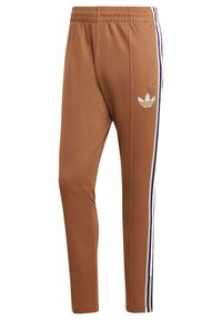 Pantalones deportivos marrones con un diseño ajustado, que presentan franjas laterales blancas y un logo bordado en la cadera izquierda. Cintura elástica.
