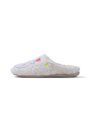 Zapatilla blanca y peluda con una cara sonriente y un diseño de corazón rojo en la parte superior, con una suela beige y un pequeño detalle verde en el lateral.