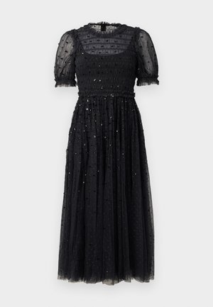 Vestido negro con mangas cortas abullonadas y un cuerpo fruncido, que presenta una falda de tul en capas adornada con pequeños lentejuelas en toda su superficie.