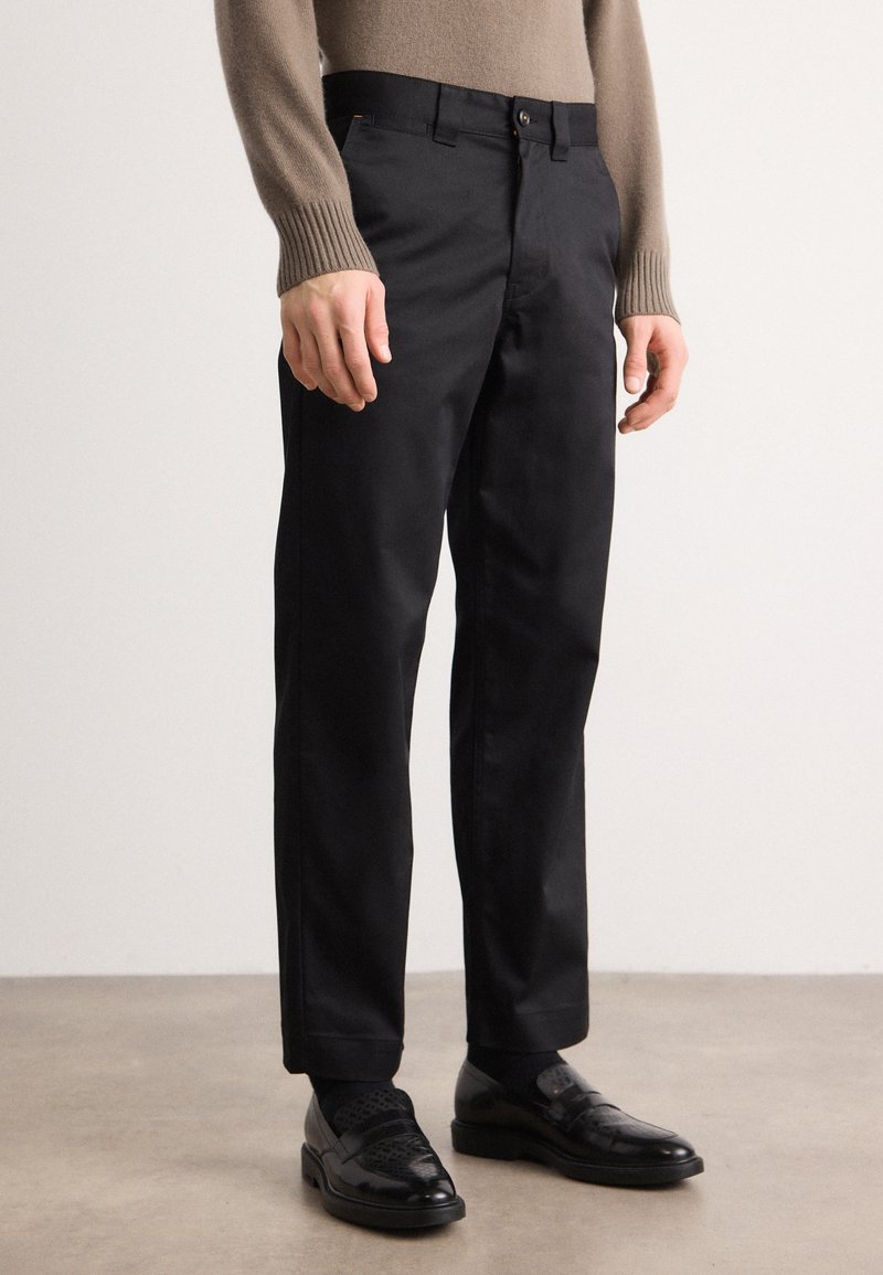 Svarta skräddarsydda byxor med en slät yta, med en klassisk rak ben-design, bältesöglor och en knappstängning.