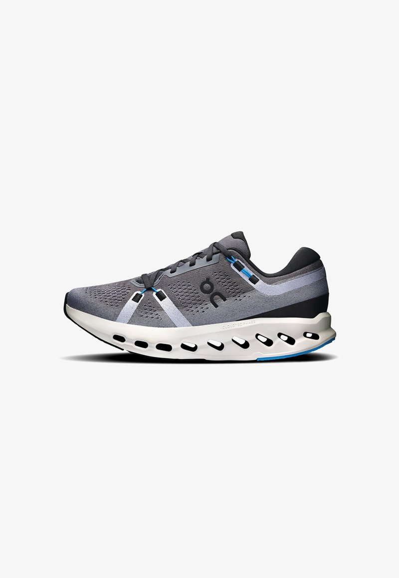 Chaussure de course légère grise avec logo noir, semelle blanche coussinée avec des trous noirs, et accents bleus sur les lacets et le bord de la semelle.