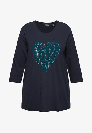 Ciemnoniebieska bluzka z długim rękawem z grafiką w kształcie teal serca z napisem "PEACE LOVE" w kwiatowym wzorze. Miękki materiał bawełniany, fason w serek.