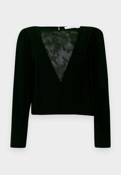 Top preto de mangas longas com decote em V profundo e inserção de renda transparente. Apresenta detalhes franzidos nos ombros e uma silhueta ajustada. Fecho de correr nas costas.