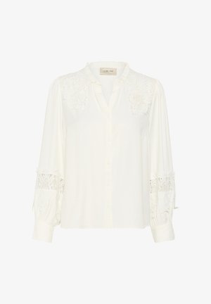 White shirt made of soft fabric, featuring lace detailing at shoulders and cuffs, button front, and a gently ruffled collar.