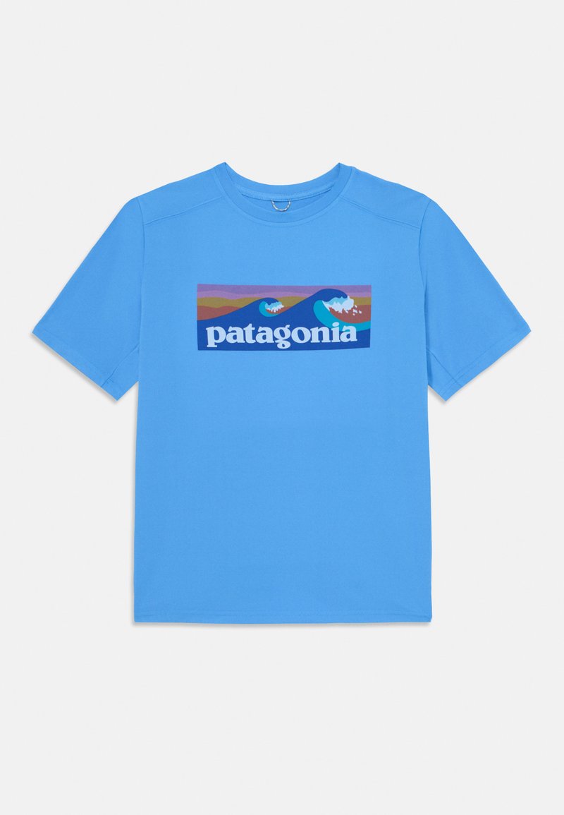 Zils kokvilnas T-krekls ar taisnstūra Patagonia logo, kurā attēloti viļņi un kalni spilgtās krāsās, īsām piedurknēm un apaļu kakla izgriezumu.
