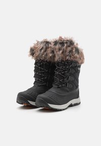 Bottes de neige noires avec garniture en fausse fourrure marron, devant à lacets et semelles blanches robustes conçues pour l'hiver.