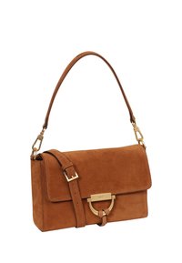 Braune Wildleder-Handtasche mit Klappverschluss, goldfarbenen Beschlägen, verstellbarem Riemen und einem runden Akzent in der Mitte. Glatte Textur.