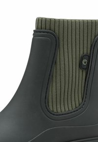 Black waterproof boot with elastic green ribbed textile upper. Features smooth rubber body and curved heel detail for a snug fit.