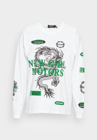 Camisola de manga longa branca com uma ilustração de dragão preto e texto verde. Inclui vários patches de logotipo verdes e pretos, em material de algodão.