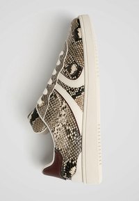 Baskets avec un imprimé serpent texturé en nuances de beige et marron. Accents blancs et semelle claire avec un design classique à lacets.