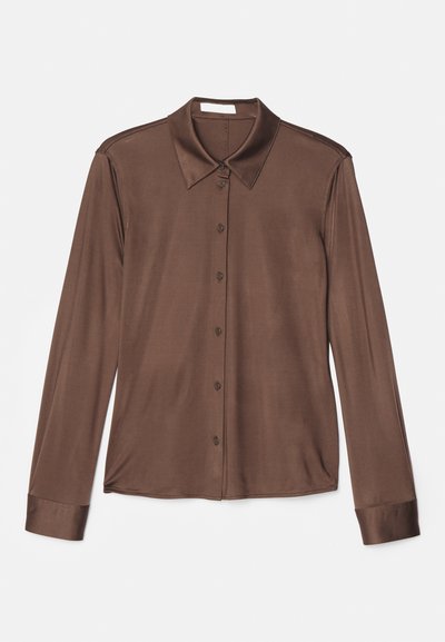 Brązowa koszula z długim rękawem z klasycznym kołnierzykiem, z zapięciem na guziki oraz gładkim materiałem o delikatnym połysku. Mankiety również są brązowe i dopasowane.